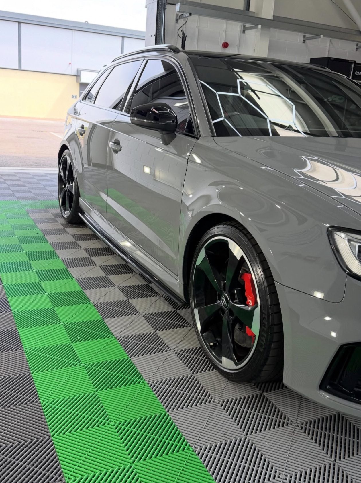 Audi RS3 on lime green and dark grey checkerboard