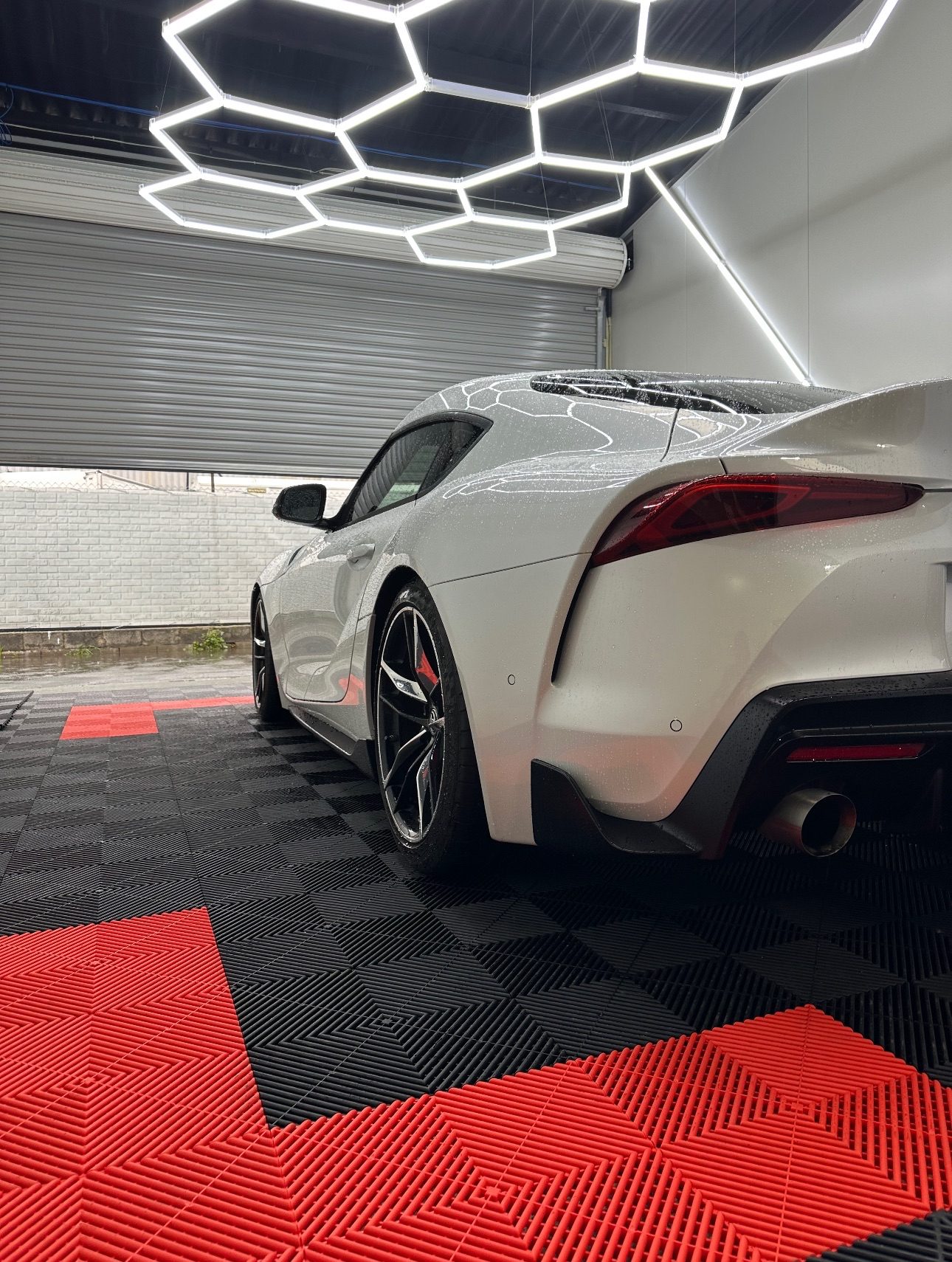 Toyota Supra on black and red tiles with hex lighting