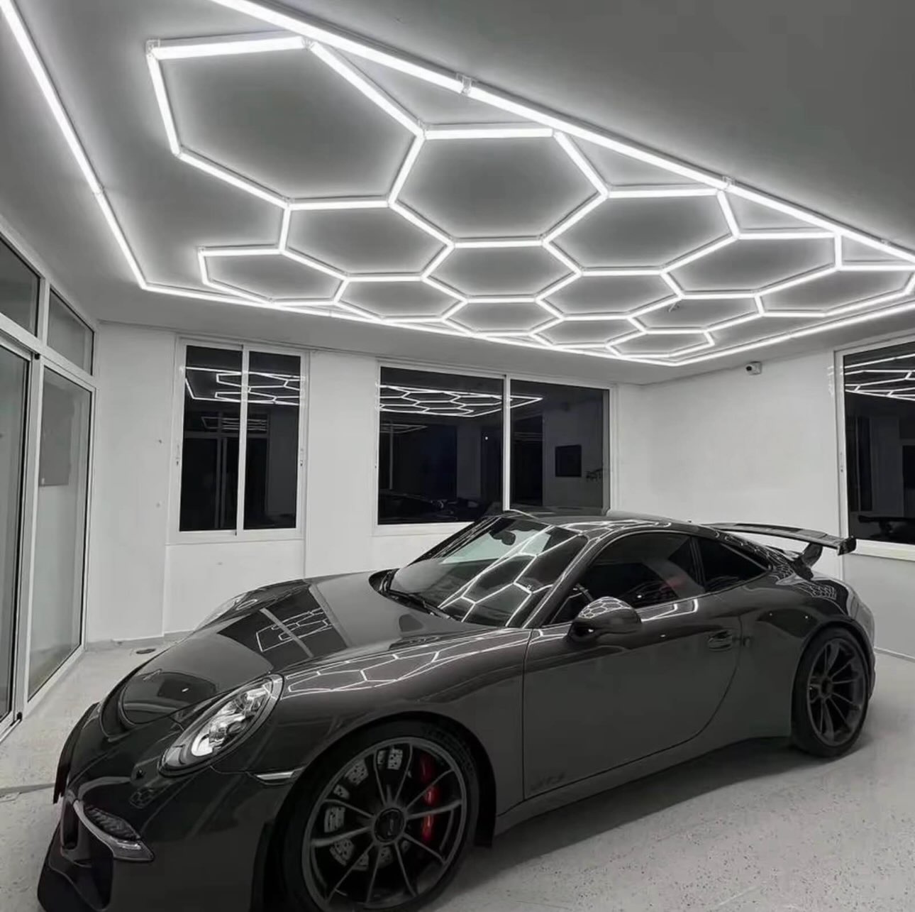 Hexagon LED light set installed over Porsche 911 in professional garage showroom